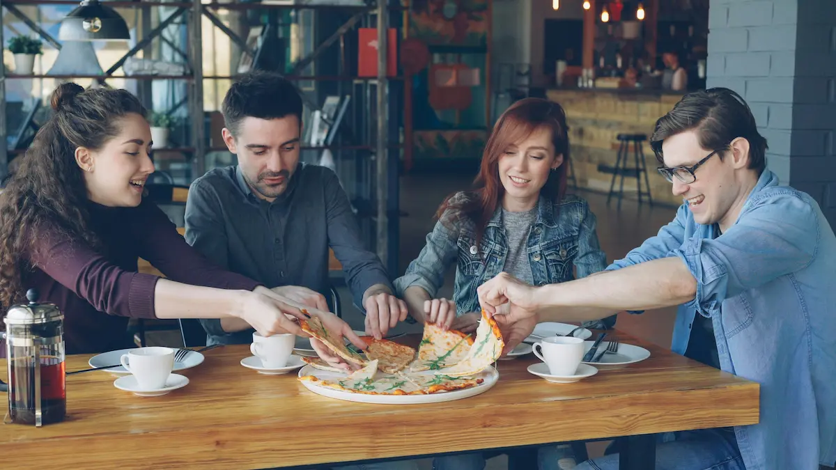 Adults enjoying pizza together